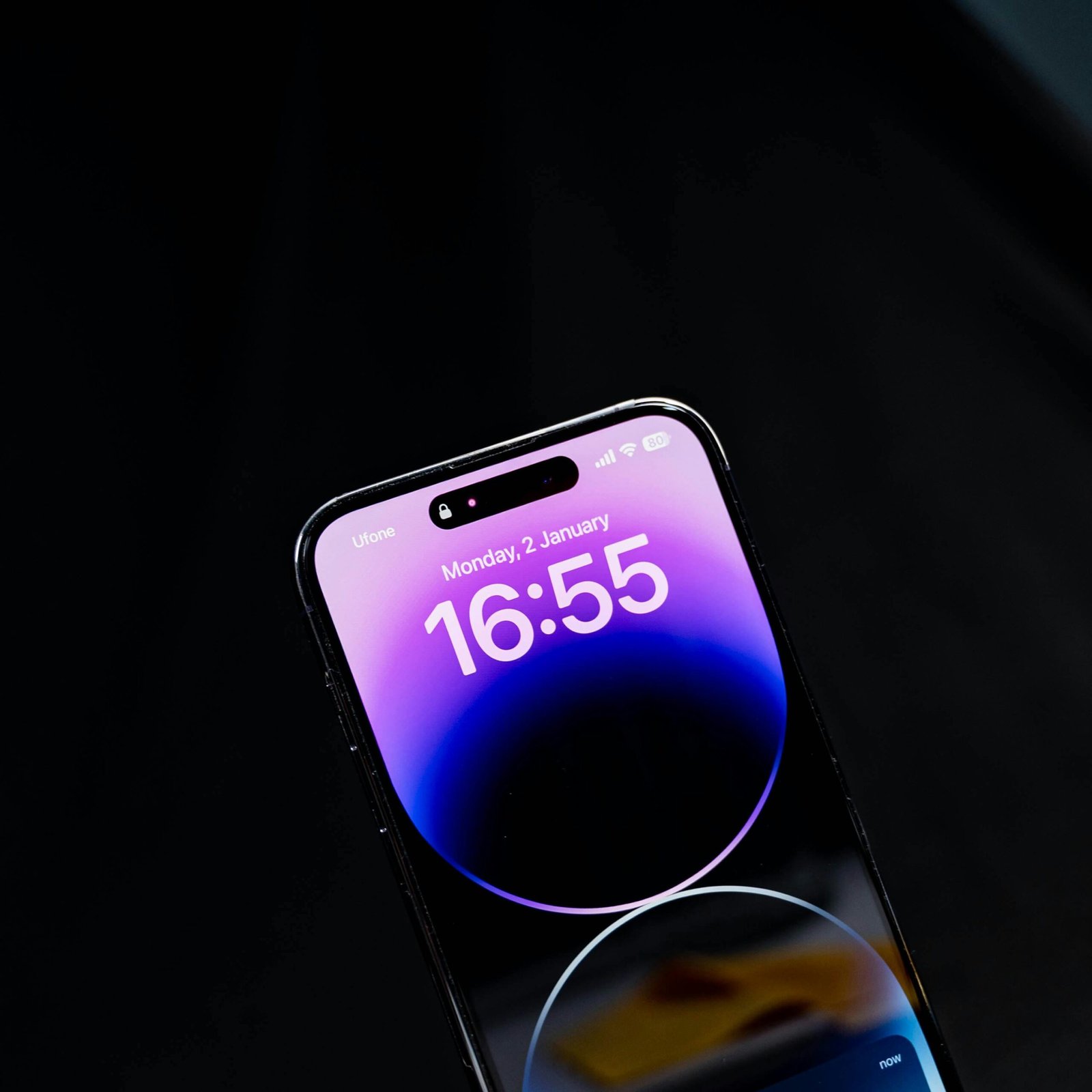 Sleek modern smartphone displaying time against a black background in vertical orientation.